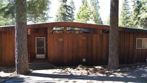 A wooden cabin with a metal door, surrounded by trees. - Tahoe City Cabin~Spectacular Lake View! Walk to Lake and City * WIFI* (Tahoe City)