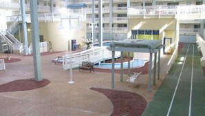 A multi-level indoor atrium with a central pool, multiple balconies, and a running track.