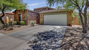 A two-story house with a garage, surrounded by desert landscaping and trees. - 2400 sq. ft., 4 bedroom, 2 bath, sleeps 8, hot tub (Goodyear)