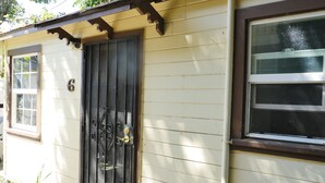 Une maison avec une porte noire, une fenêtre et le numéro 6 sur la porte.