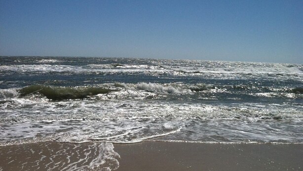 A beach with waves crashing onto the shore under a clear sky. - East End -Beach Oasis- St. George Island. Beach Condo / Full Sized Swimming Pool (St.George Island)