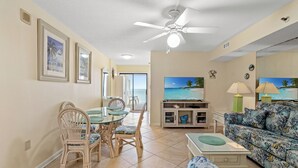 A living room with a dining area, a ceiling fan, and a TV. - Oceanfront Condo with indoor pool + Free Attraction Tickets! (North Myrtle Beach)