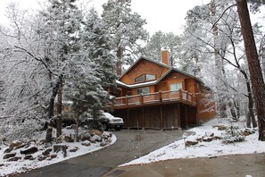 A wooden cabin with a balcony, surrounded by snow-covered trees and rocks. - 30 night minimum stay, Log Style Cabin in Moonridge, Walk To Slopes, Ntl. Forest (Big Bear Lake)