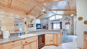 A spacious kitchen with wooden cabinetry, a granite countertop, and a built-in dishwasher. - 30 night minimum stay, Log Style Cabin in Moonridge, Walk To Slopes, Ntl. Forest (Big Bear Lake)