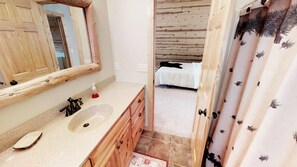 A bathroom with a wooden vanity, a sink, and a mirror.