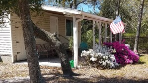 A small, single-story house with a porch and an American flag. - Turtle Time - 4 Bd House Near Holden Beach - escape the crowds! (Supply)