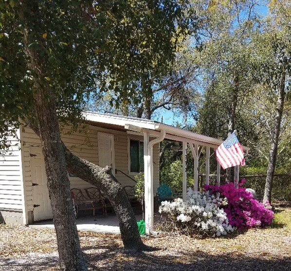 A small, single-story house with a porch and an American flag. - Turtle Time - 4 Bd House Near Holden Beach - escape the crowds! (Supply)