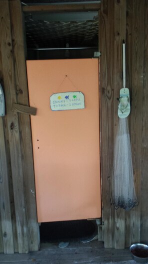 A wooden door with a sign indicating shower costs. - Turtle Time - 4 Bd House Near Holden Beach - escape the crowds! (Supply)