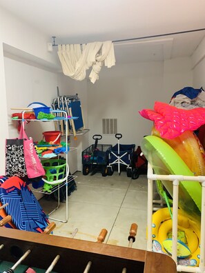 A storage room with shelves holding cleaning supplies, a mop, and a cart. - 🏝🏖 Spacious Luxury 4/3 Townhouse  in Gulf Front Gated Community (Pensacola Beach)