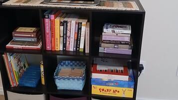 A bookshelf with various books and storage boxes.