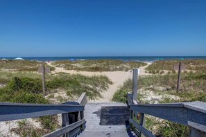 A wooden boardwalk leading to a beach with dunes and a clear sky. - Life Is Swell - Oceanfront, Pool, & Tennis (Fernandina Beach)