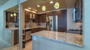 A modern kitchen with dark wood cabinets, stainless steel appliances, and a marble countertop. - On The Beach !!!  2 Minutes to Exquisite Dinning and Shopping (Hallendale Beach)