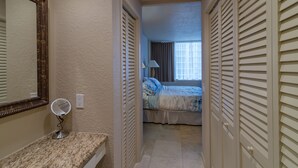 A hotel room with a bed, a bathroom with a mirror and sink, and a view of the outside through the window. - On The Beach !!!  2 Minutes to Exquisite Dinning and Shopping (Hallendale Beach)