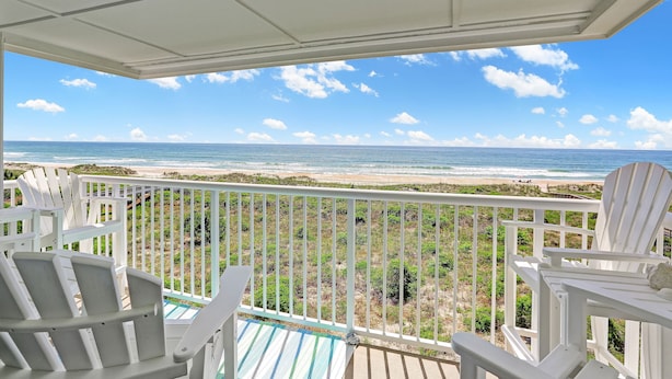 A balcony with white chairs overlooking a beach and ocean. - Gorgeous TOP Floor - Oceanfront Luxury Condo with Garage and Elevator! (Wrightsville Beach)