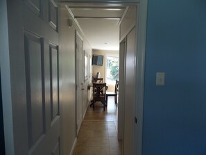 Stunning hallway leads to a dining area with a flat-screen TV and comfortable seating.