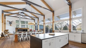 A spacious kitchen with a large island, wooden beams, and a view of mountains. - 5-Star Lodge \ Groups Welcome  \ 1 Mile from Downtown (Leavenworth)
