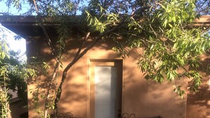A building with a balcony featuring a wrought iron railing and a small table. - Lake front getaway! Casita d’Amore (Granite Bay)