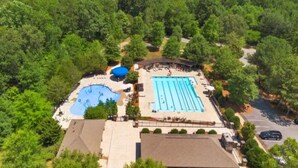 An aerial view of a resort with a swimming pool, a water slide, and a covered area. - Couples Retreat with Hot Tub, Lake & Mountain Views in Big Canoe Luxury Resort (Jasper)
