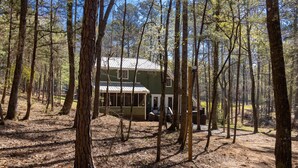 A cabin surrounded by tall trees in a forest. - Awesome Lakefront House on West Point Lake in LaGrange, Ga (Lagrange)