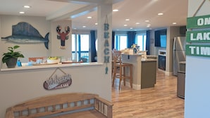 Una cocina con una isla central, un comedor con banco y vistas al lago.