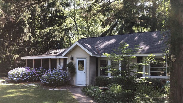 A house with a porch, a door, and a garden with flowers. - Beautiful Private Harbert Beach cottage well appointed on a quiet private lane (Harbert)