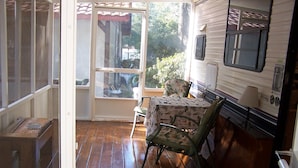 A cozy RV interior with a wooden floor, a table with a floral tablecloth, and a chair. - Lets Go Camping In Comfort, Southern Style, come on down. (Summerdale)
