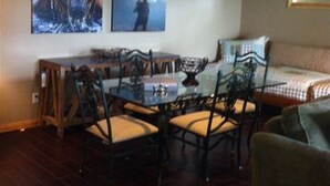 A cozy living room with a dining area, a bed, and two wall-mounted televisions. - Most Beautiful View on Table Rock Lake! (Shell Knob)