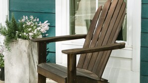 A wooden Adirondack chair in front of a house with teal siding and white trim. - The Guesthouse at The Waters, Walk to Chapel, Pool & Town Square (Pike Rd)