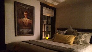 A bedroom with a bed, pillows, a poster, and a window. - Thaddeus Stevens' Gettysburg Log Home (Gettysburg)
