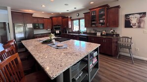 A modern kitchen with granite countertops, stainless steel appliances, and wooden cabinetry. - The Perfect Green Lake Family Getaway (Green Lake)