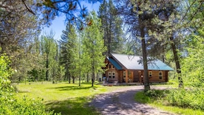 A log cabin with a porch, surrounded by a forest. - Steps to the River! River Edge Cabin (West Glacier)