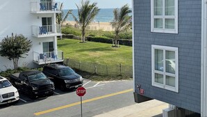Un immeuble à plusieurs étages doté de balcons donnant sur une plage.