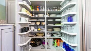 Kitchen is well stocked with dishes, glassware, pots, pans and other essentials