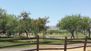 A golf course with a wooden fence, trees, and a pond. - Charming Tubac Villa located within Tubac Golf Resort (Tubac)