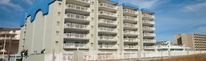 Un hotel de varios pisos con balcones, techo plano y cielo despejado.