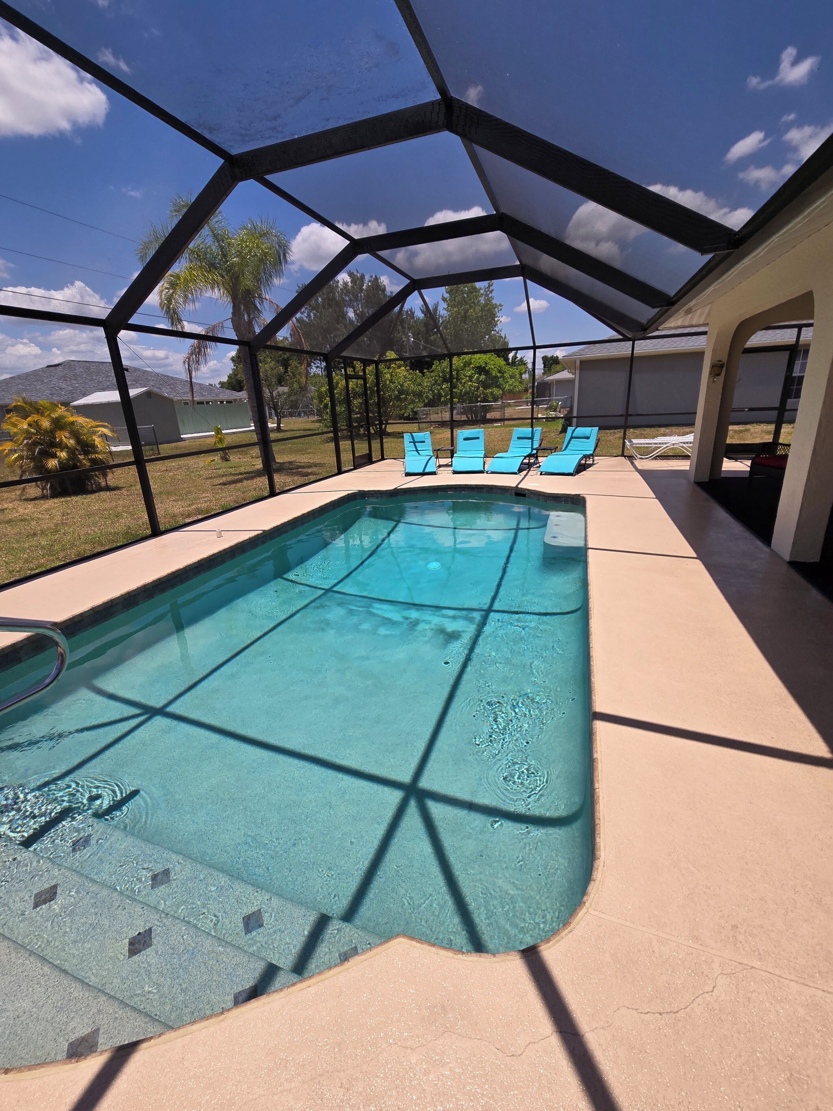 Ein überdachter Pool mit klarem, blauem Wasser, umgeben von einer schattigen Liegefläche.