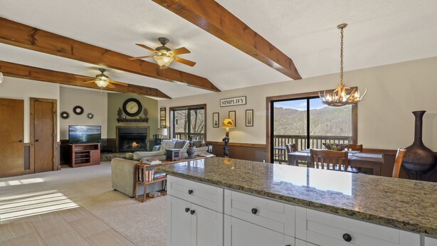 A spacious living room with a fireplace, a large TV, and a dining area with a view. - Relaxing Cozy Cabin in the Heart of the Blue Ridge Mountains. Pet friendly (Foscoe)