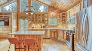 Una cocina amplia con armarios de madera, una isla grande y electrodomésticos de acero inoxidable.