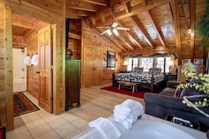 A log cabin interior with a bedroom, bathroom, and a dining area.