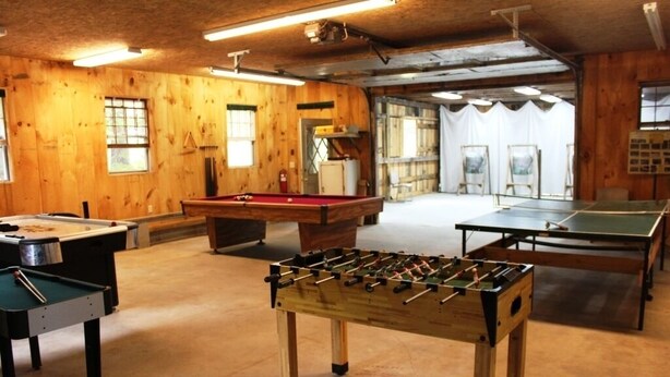 Une pièce équipée d’une table de billard, d’un baby-foot et d’une table de ping-pong.