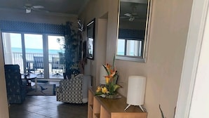 Un pasillo con una consola de madera, un espejo y una planta en maceta.