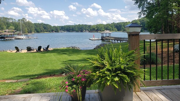 A deck with a view of a lake, dock, and boats. - Lake Front Getaway, Family Friendly. (Mooresville)