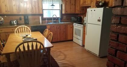 Charming cedar log cabin nestled in the woods, footsteps from Rowley's Bay