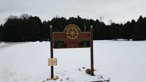 A sign for Wagon Trail Vacation Homes with a 'No Outdoor Fires' sign below it.