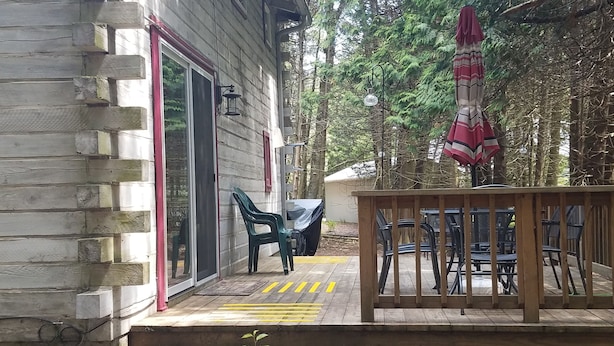 A wooden deck with outdoor furniture and a covered seating area.