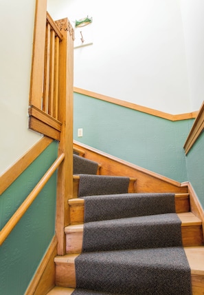 Eine Treppe mit hölzernen Geländern und Teppichstufen.