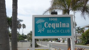 A sign for Coquina Beach Club with the year 1906. - Coquina Beach Club 110, Beachfront Studio. Booking late summer weeks. (Bradenton Beach)