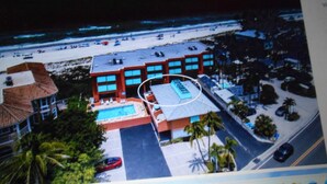 A hotel with a pool, beach view, and a parking area. - Coquina Beach Club 110, Beachfront Studio. Booking late summer weeks. (Bradenton Beach)