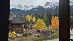 A mountain cabin with a deck and a view of snow-capped peaks. - Premium penthouse in the heart of the Canadian Rockies! Walk to busy downtown. (Canmore)
