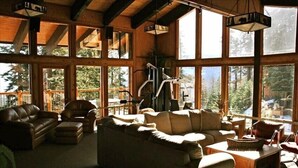 A spacious living room with large windows, a fireplace, and a variety of seating options. - LUXURY VIEW CONDO/SKI-IN/SKI-OUT/TO CANYON/EAGLE EXPRESS (Mammoth Lakes)